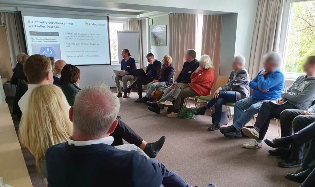 Foto: Die Arbeitsgruppe 4 sitzt in einem Kreis und verfolgt den Vortrag von Nils Dreyer.